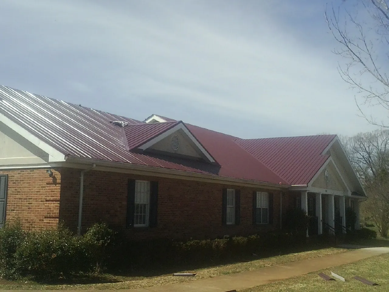 Red metal roof with gabled entries on a long brick building in Pocono Summit
