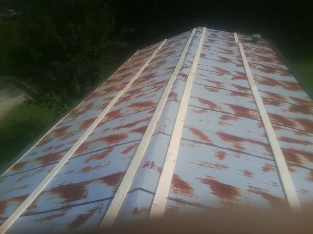 Rusted metal roof panels with new wood purlins before replacement — Storm Damage Roof Repair in Pocono Summit by Roofing Brothers