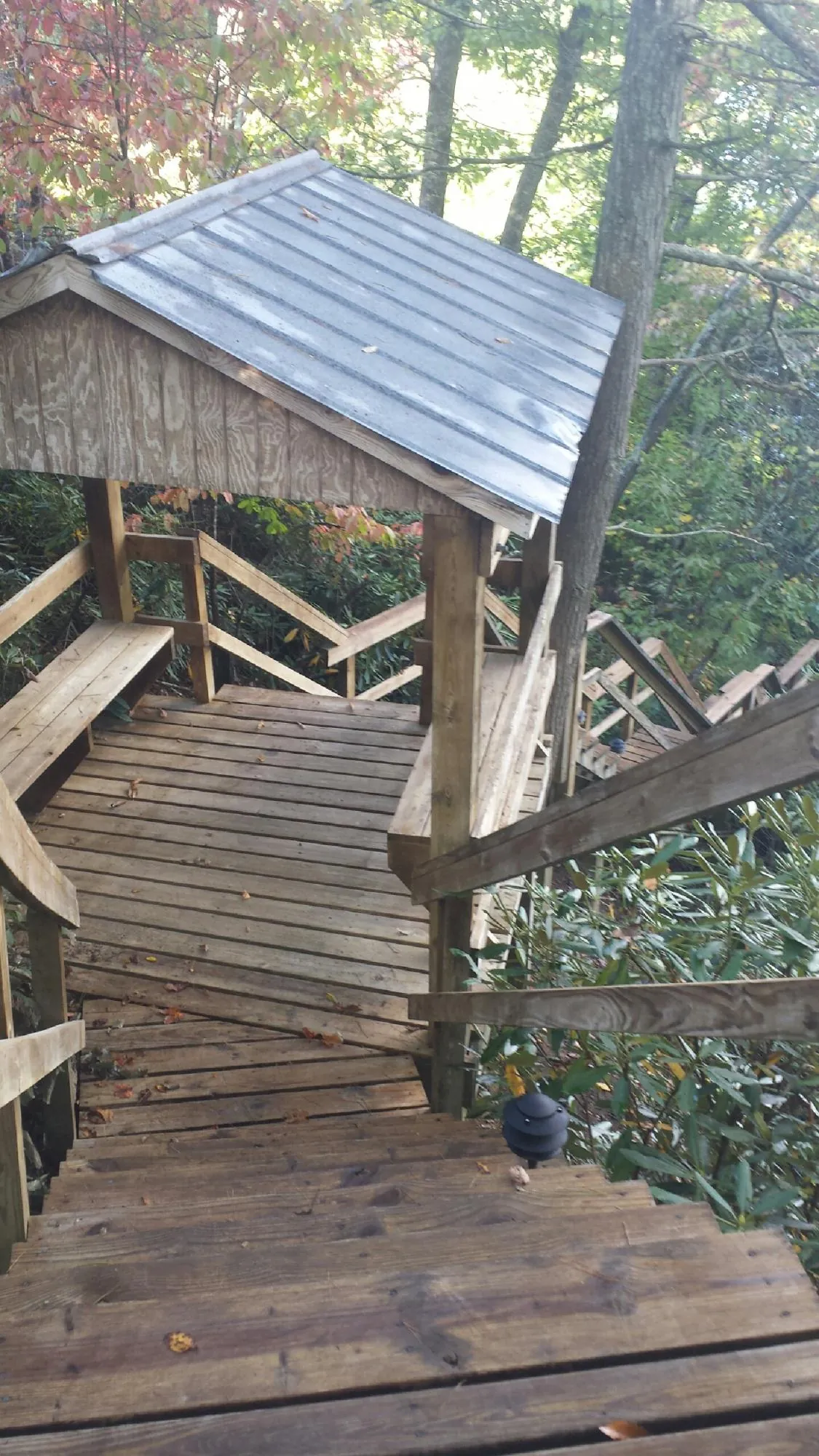Metal roofed shelter over wooden steps on a wooded walkway — Skylight Repair & Installation work by our crew in Pocono Summit